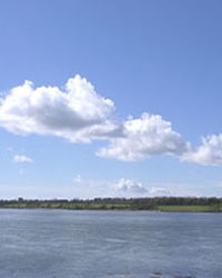 A 'street' of small cumulus clouds across the Menai Strait on 2 May 2002. View from Llanfairisgaer Church on mainland looking across to Anglesey. Photo: &copy; D Perkins.