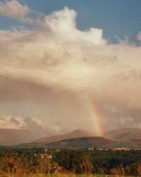Rainbow over the Snowdonia Mountains seen across the Menai Strait from Four Crosses at 1825 GMT on 20 August 2000. Photo: &copy; D Perkins.