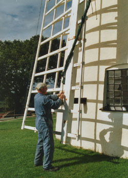 The assistant miller 'Will' furling the sails after a day's milling. Photo: © 2000 D. Perkins.