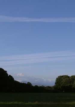 Cumuls clouds over Snowdonia with contrails overhead at 0556 GMT on 20 July 2001. Photo &copy; D Perkins.