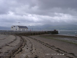 Low water at Beaumaris on a dull and windy day. View at 0941 GMT on 29 June across the Menai Strait shows the 'Blue Peter' Lifeboat Station and the cloud covered Snowdonia Mountains. Photo: &copy; D.Perkins 2000.